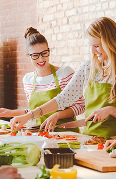 Two women cooking and laughing